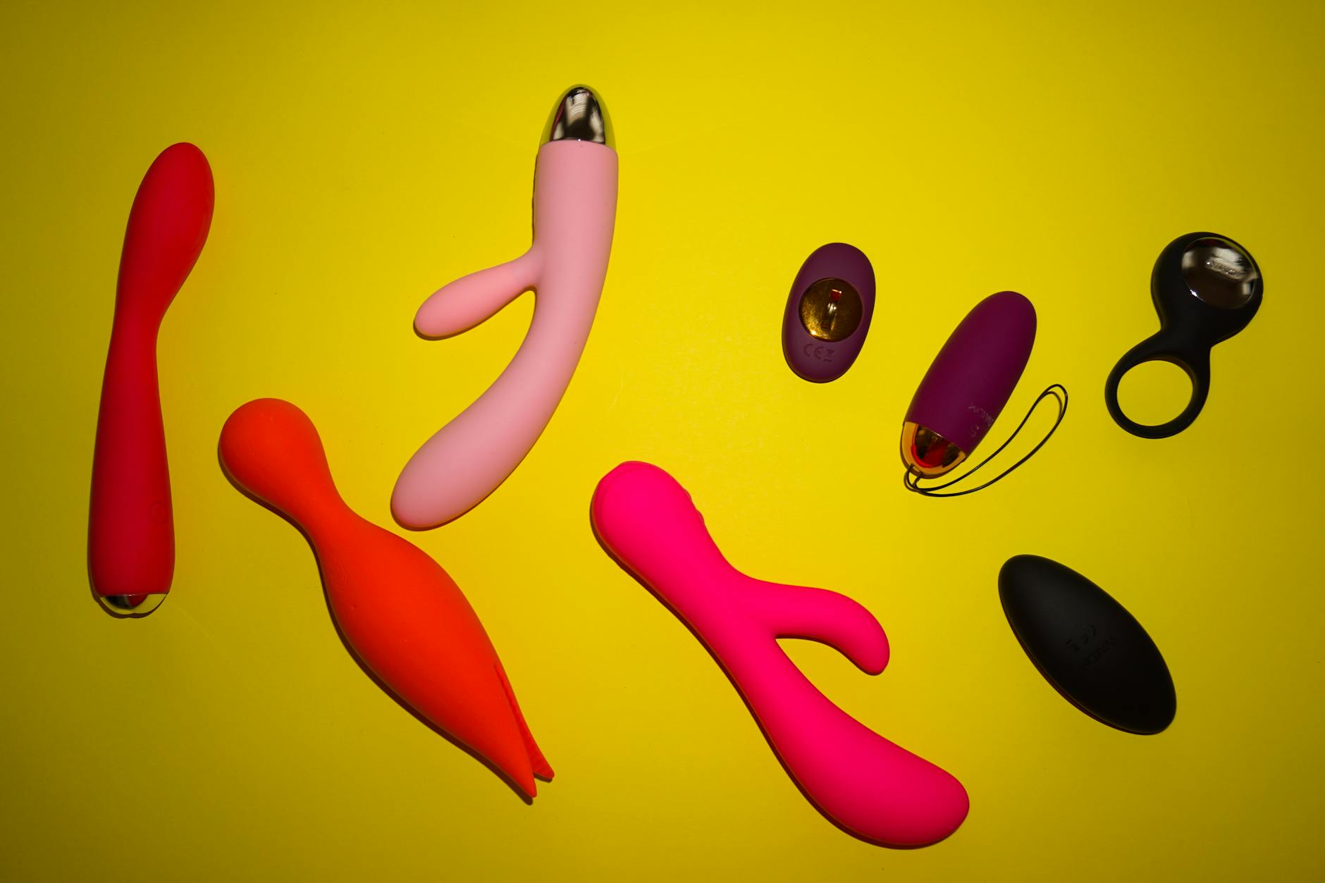Yellow silicone vibrator surrounded by bananas on a yellow background